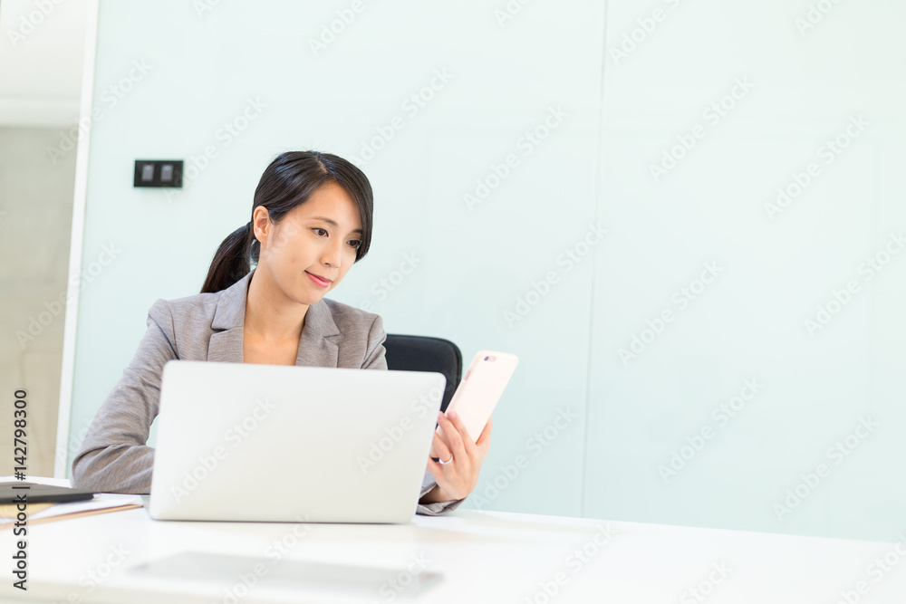Businesswoman woman using cellphone and laptop computer in conference room Businesswoman woman using cellphone and laptop computer in conference room