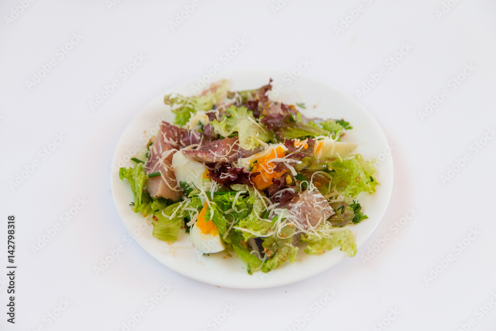 Dietary salad. Lettuce, fish, egg, plate isolated on white background