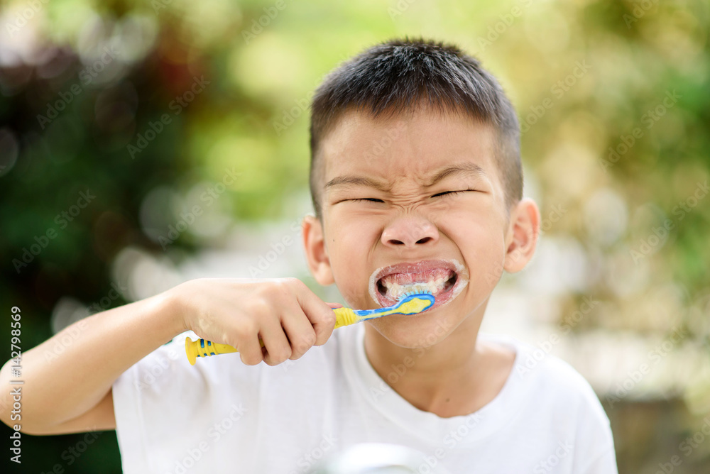 Boy brushing teeth in the garden Boy brushing teeth in the garden