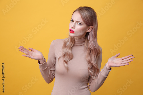 Confused young blonde lady with bright makeup lips