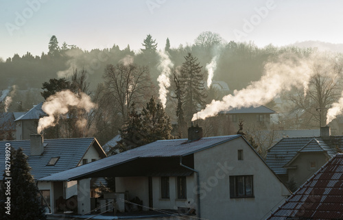 Fototapeta Smoking chimney smoke pollution, small house town in Europe