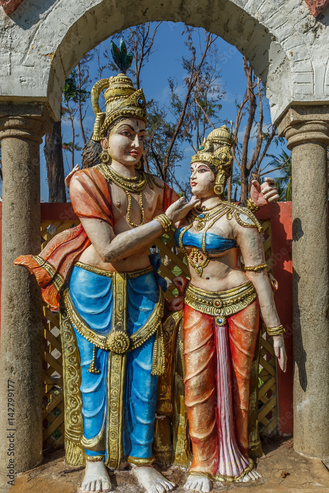 Fototapeta premium Narrow view of an ancient colorful sculpture of a men, seen talking with a women, Chennai, Tamil nadu, India, Jan 29 2017