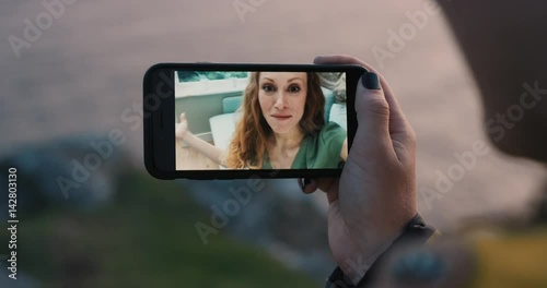 Wallpaper Mural Young woman having video chat holding smartphone webcam chatting to attractive redhead girlfriend outdoors by the ocean at sunset Torontodigital.ca