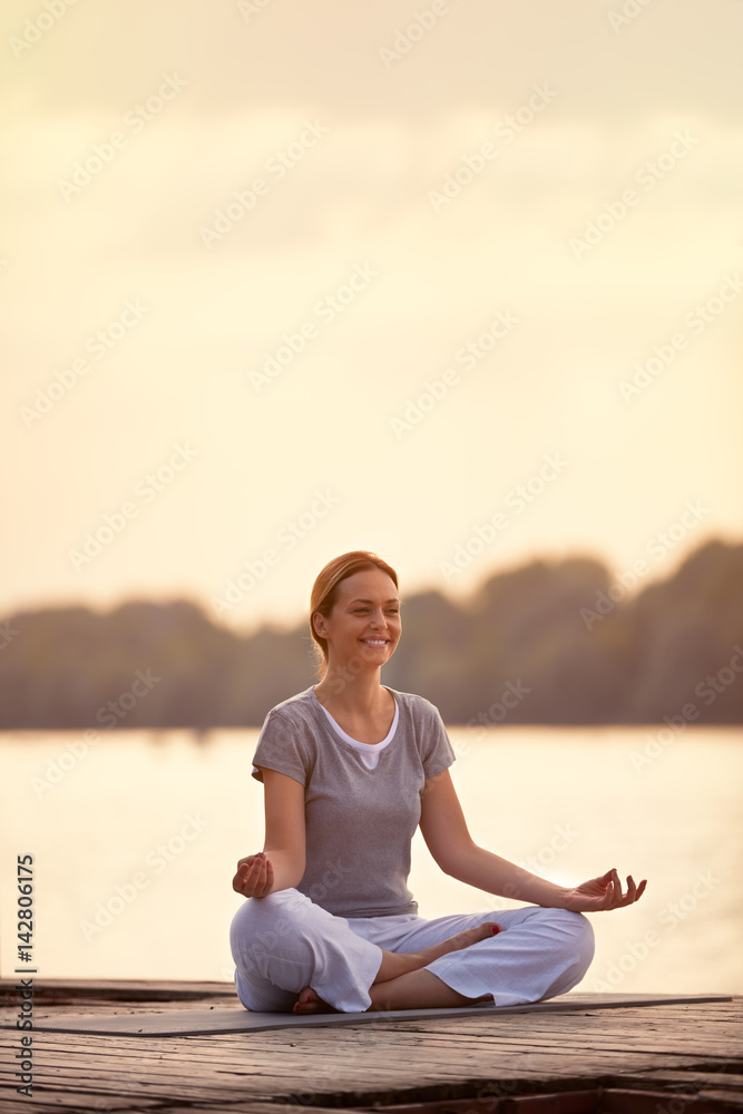 Fototapeta premium Female person on river in yoga pose