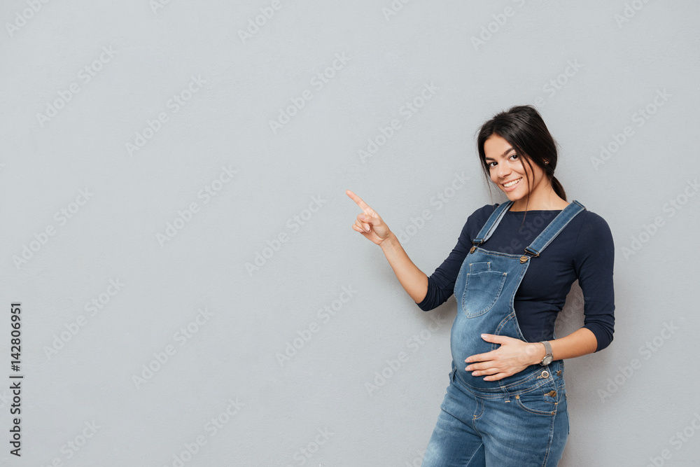Cheerful pregnant lady pointing. Cheerful pregnant lady pointing.