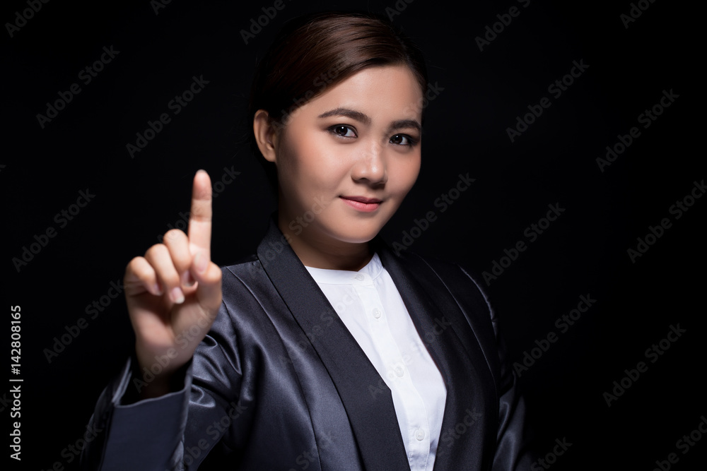 Businesswoman show finger pointing on dark background