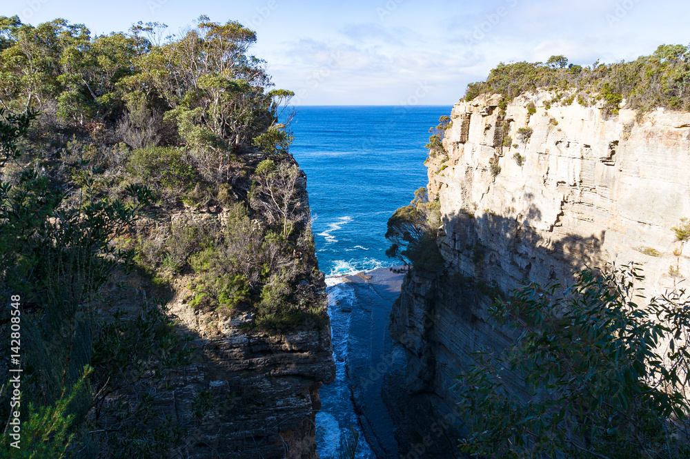 Narrow ocean passage, path among high cliffs, mountains