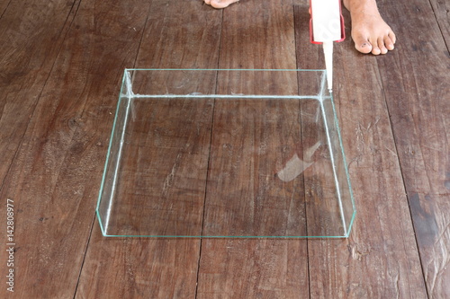 Men are firing silicone to clear the glass to a rectangular shape for feeding fish.