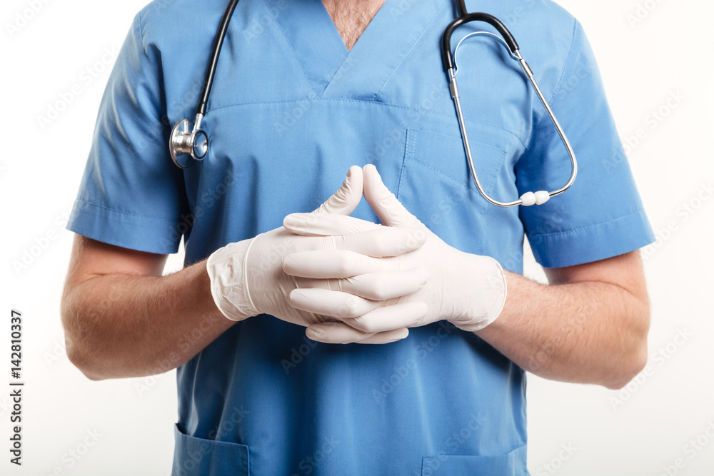 Male medical doctor or nurse wearing surgical gloves and stethoscope Male medical doctor or nurse wearing surgical gloves and stethoscope
