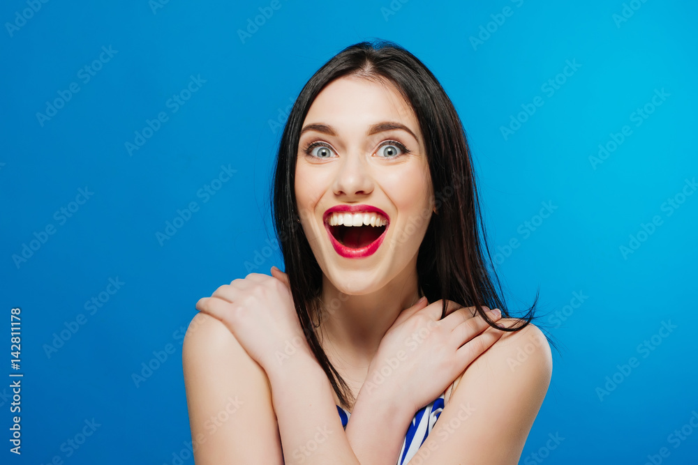Surprised young pretty girl looking at the camera isolated on the blue background Surprised young pretty girl looking at the camera isolated on the blue background