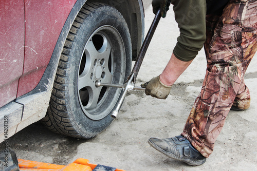 Fototapeta Naklejka Na Ścianę i Meble -  installation of passenger car wheel and replacement on spring tire.