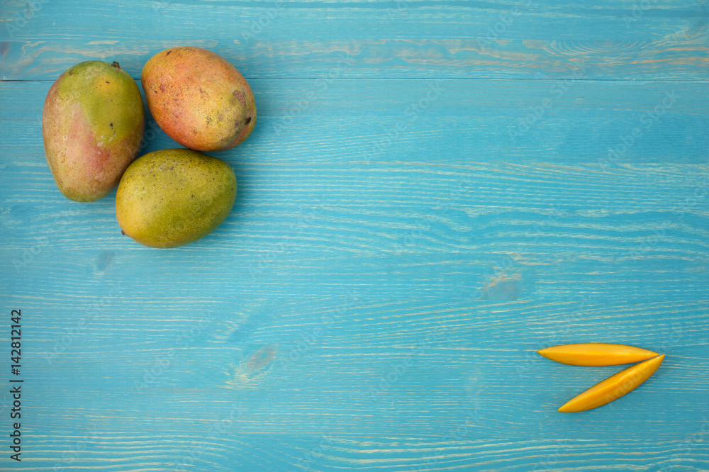 Lot of mango on blue background falt lay Lot of mango on blue background falt lay