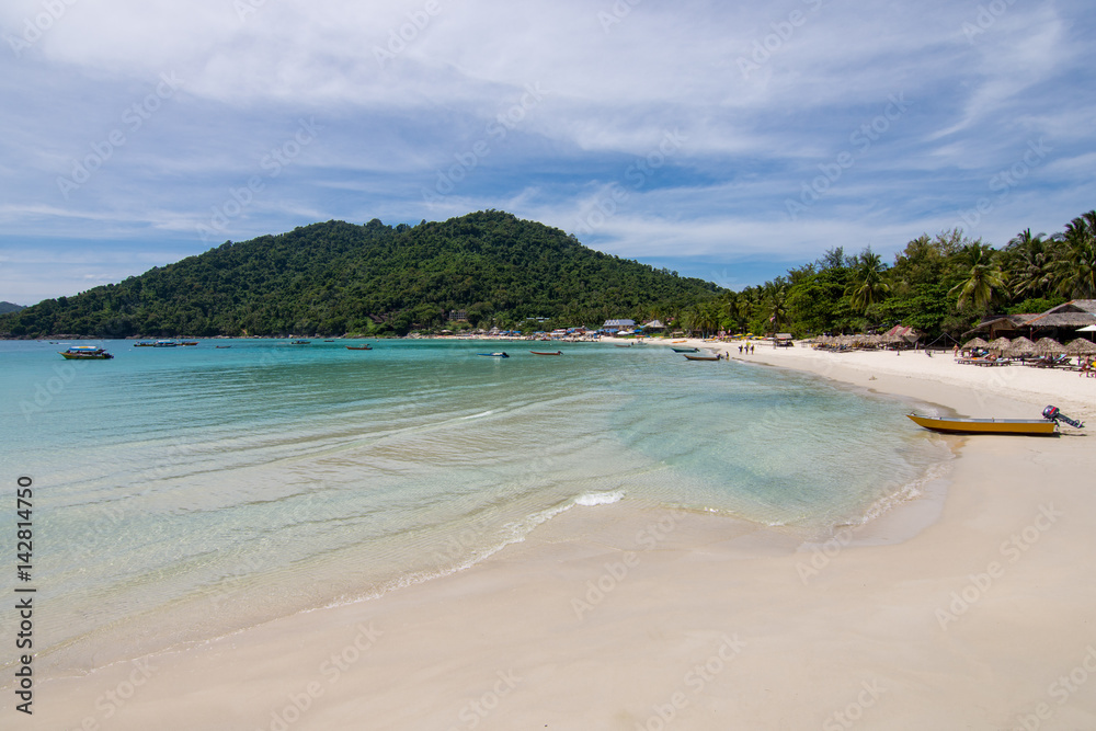 Paradise beach view with huts and small boat and a forested hill background. Perhentian Kecil, Malaysia. Paradise beach view with huts and small boat and a forested hill background. Perhentian Kecil, Malaysia.