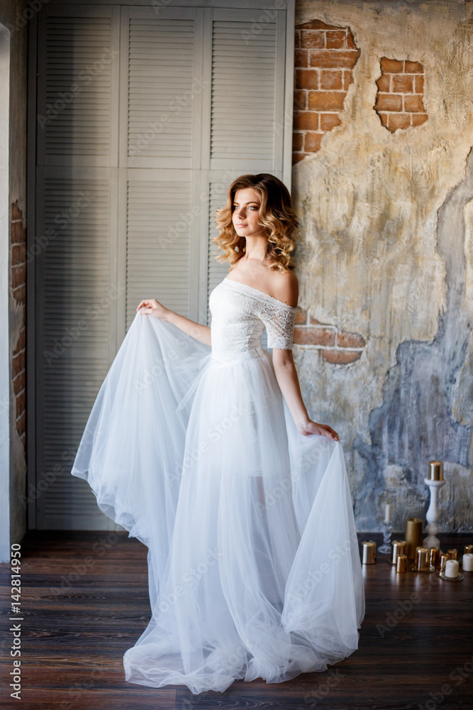 Beautiful bride in a gorgeous dress in the loft room. Beautiful bride in a gorgeous dress in the loft room.