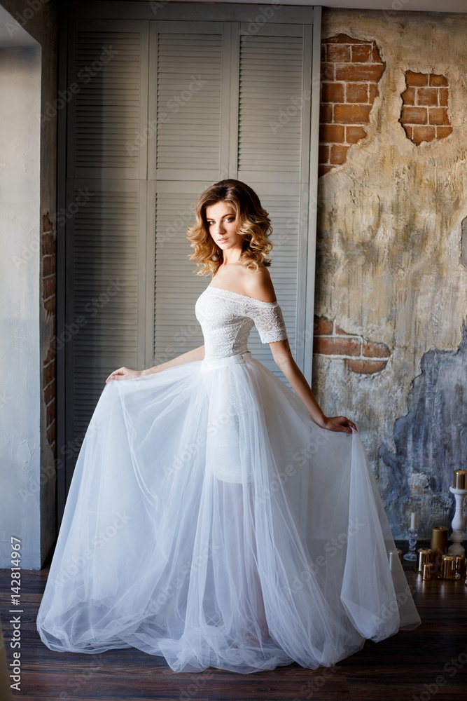 Beautiful bride in a gorgeous dress in the loft room. Beautiful bride in a gorgeous dress in the loft room.