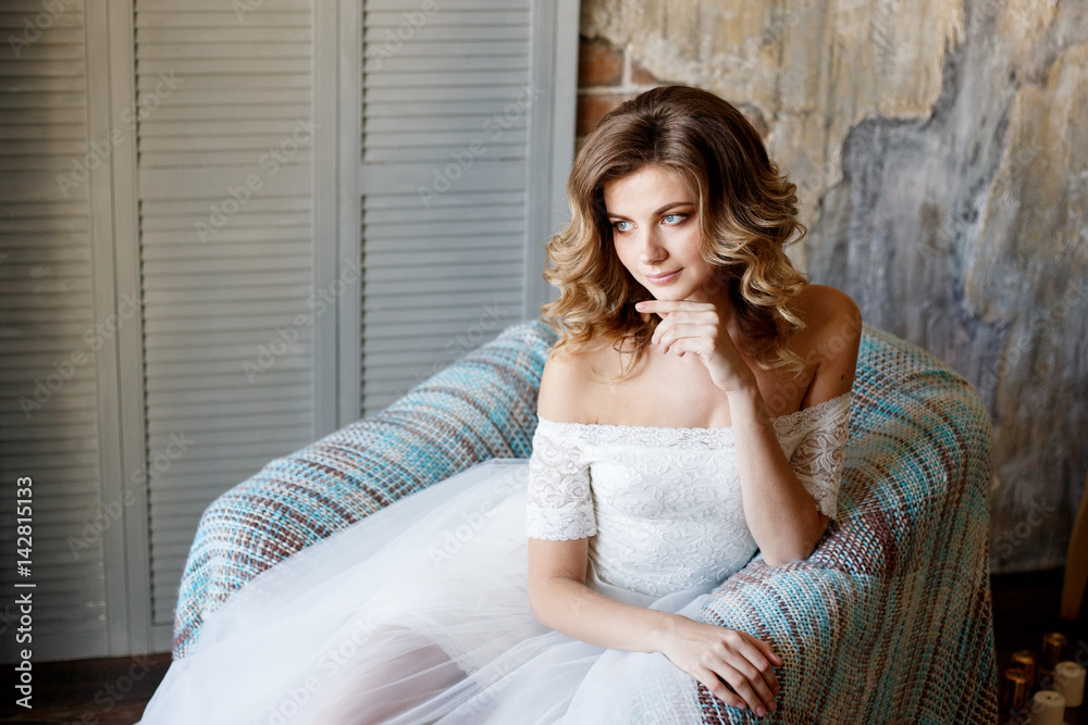 Bride in a beautiful dress near the window