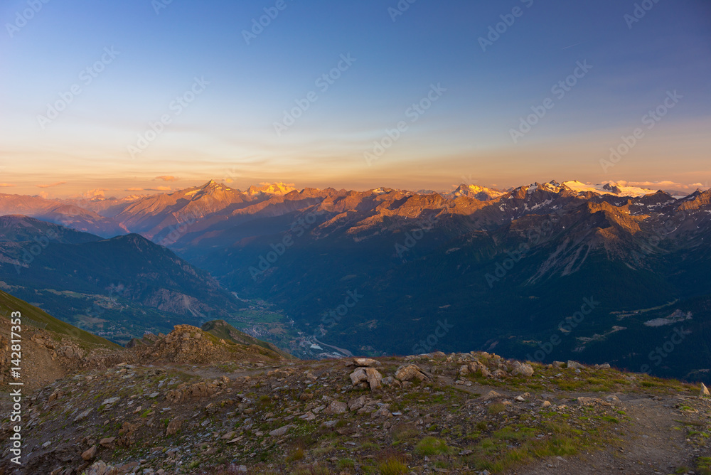 Warm light at sunrise on mountain peaks, ridges and valleys