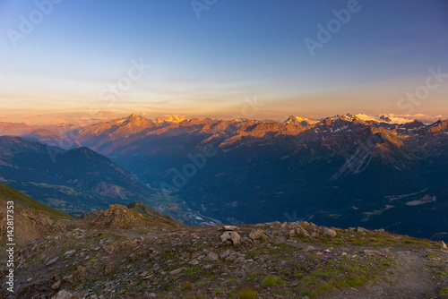 Warm light at sunrise on mountain peaks, ridges and valleys