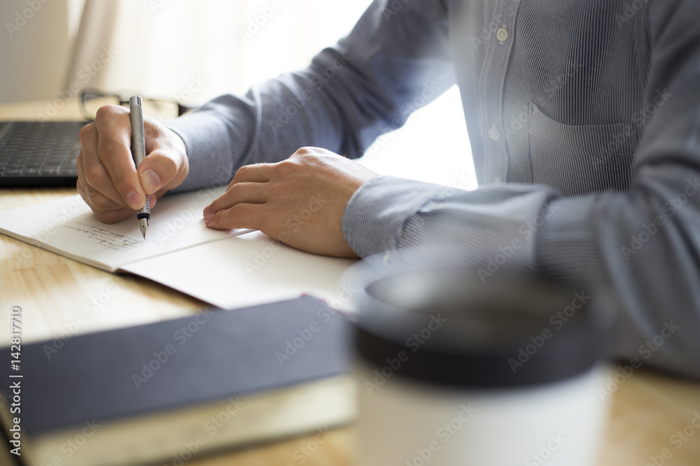 Obraz premium 机の上で仕事・勉強をする男性