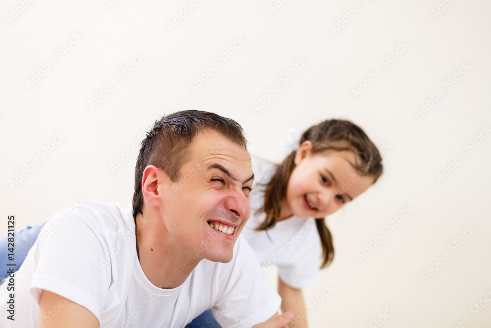Smiling father carrying on his shoulders his little daughter isolated on white background Smiling father carrying on his shoulders his little daughter isolated on white background