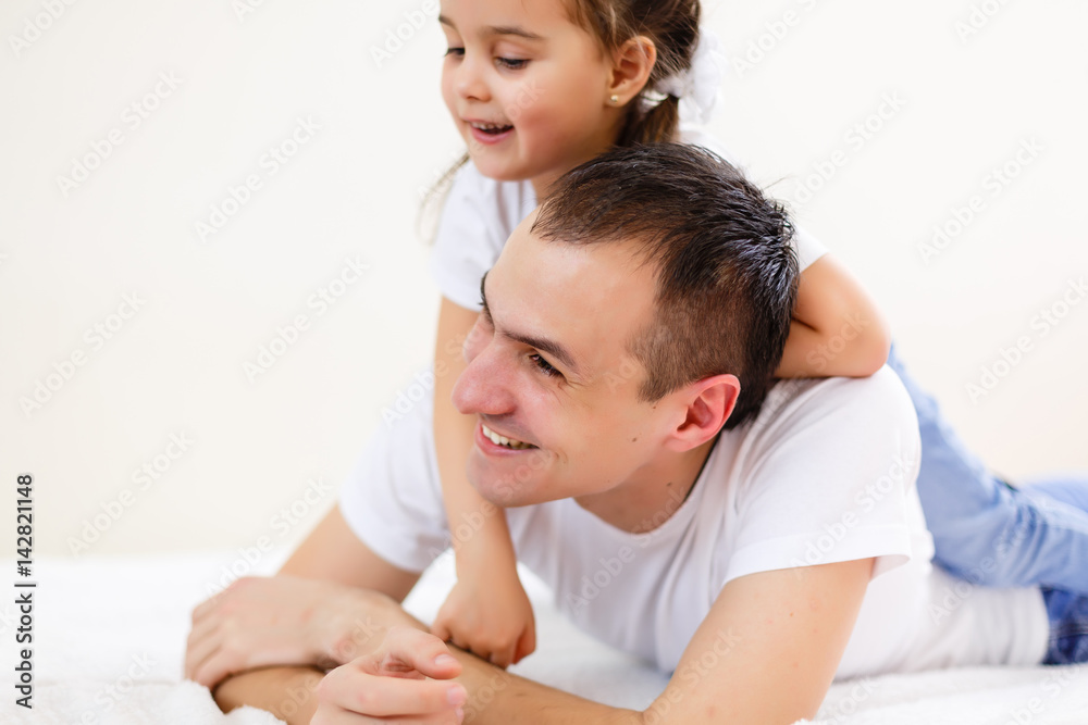 Smiling father carrying on his shoulders his little daughter isolated on white background Smiling father carrying on his shoulders his little daughter isolated on white background