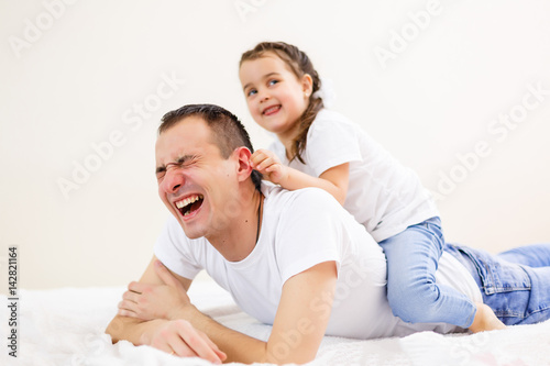 Smiling father carrying on his shoulders his little daughter isolated on white background