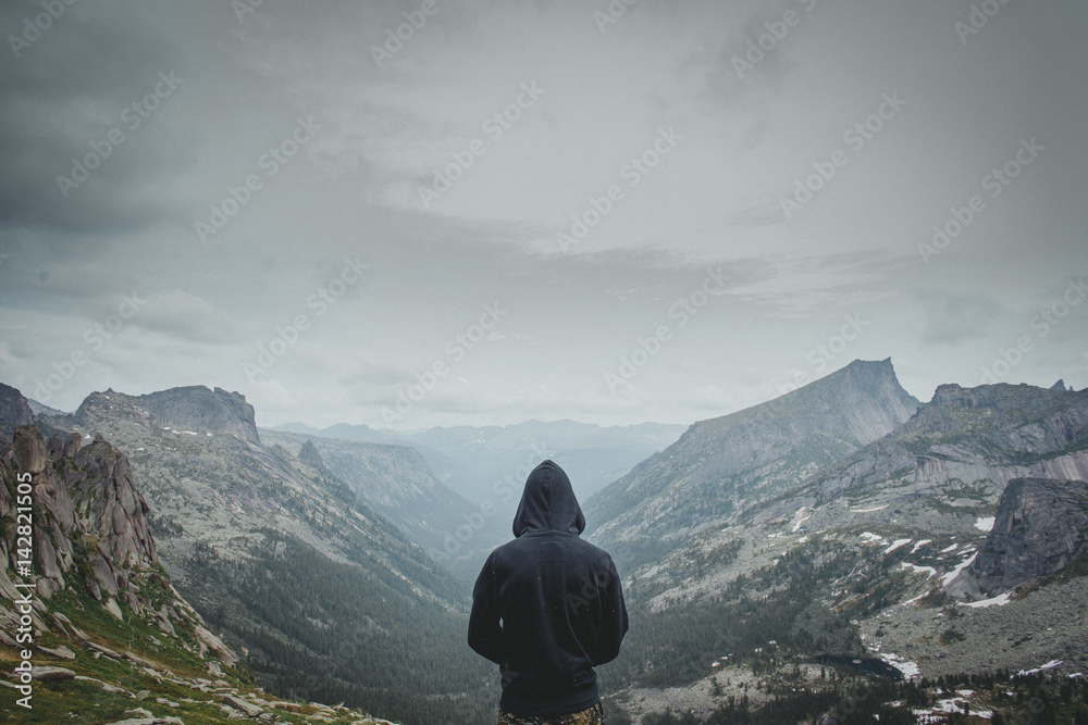 Hiking traveller tourist man in mountains. View top back