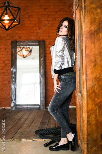 Girl posing in a silver jacket. The Studio photos. r © Aleksei Zakharov