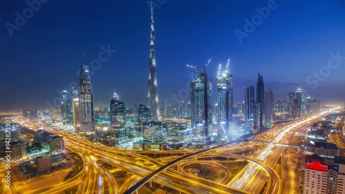 Spectacular nighttime skyline of downtown Dubai. Scenic aerial view of big highway intersection and skyscrapers. 4K time lapse.
