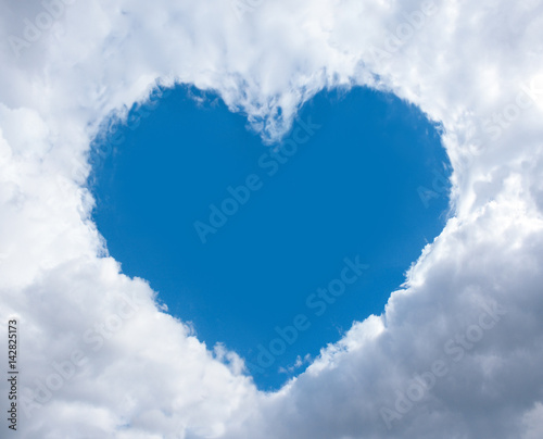heart frame made of fluffy clouds in blue sky