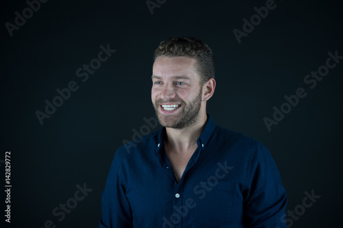 young happy man with unshaven face in blue fashionable shirt
