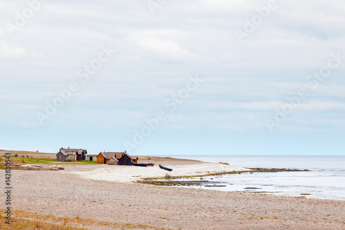 Shoreline of Gotland, Sweden with beach, water and fishing huts © Johan