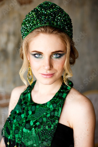 Beautiful young woman in a green jewelry