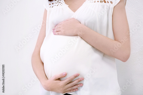 Beautiful pregnant woman on light background, closeup
