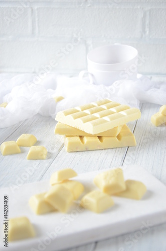 Pieces of white chocolate, black background, selective focus
