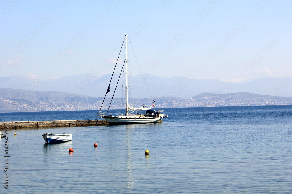 yacht moored in harbour with sea and mountain yacht moored in harbour with sea and mountain