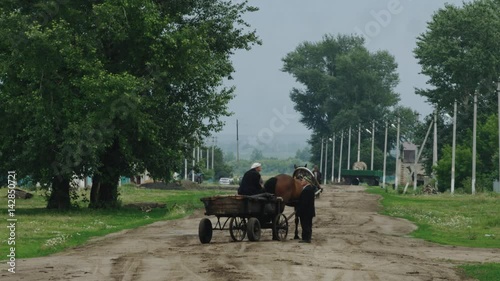 The old man on the cart communicates with the pedestrian