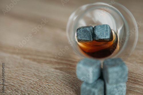 Stones for cooling whiskey and glases tulup on dark wooden background photo
