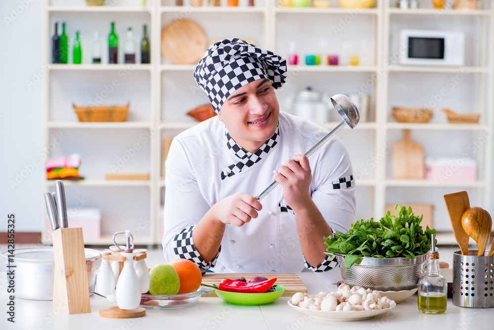 Young male cook working in the kitchen Young male cook working in the kitchen