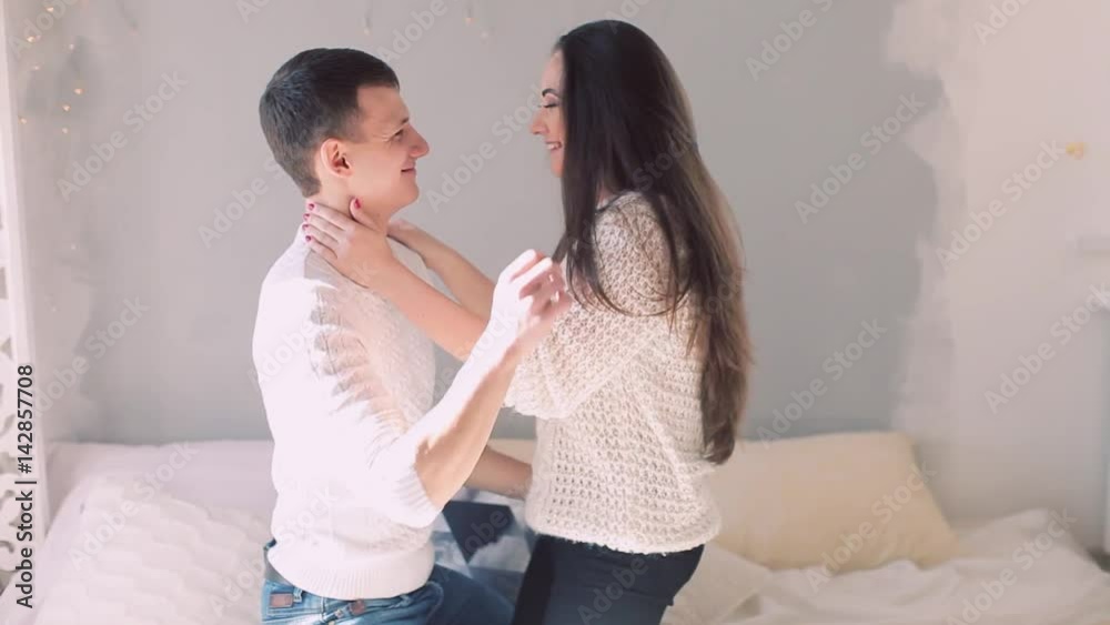 Young happy family together, girl and guy embracing in bed. Wife kissing husband. Couple European appearance. concept of happy family life, young couple living together, good morning, wake up from Young happy family together, girl and guy embracing in bed. Wife kissing husband. Couple European appearance. concept of happy family life, young couple living together, good morning, wake up from