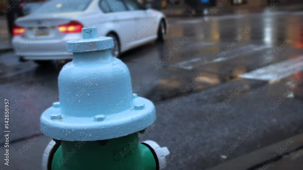 Wet Fire Hydrant covered in raindrops in busy metropolitan downtown city area Wet Fire Hydrant covered in raindrops in busy metropolitan downtown city area