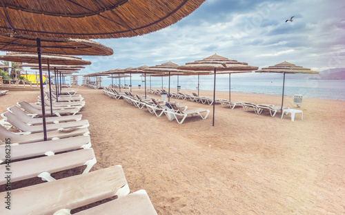 Fototapeta Naklejka Na Ścianę i Meble -  Morning at sandy beach of Eilat - famous resort city in Israel. Image slightly toned for inspiration of vacation concept