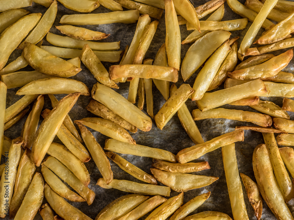 Baking tray full of homemade potato fries straight out of the oven Baking tray full of homemade potato fries straight out of the oven
