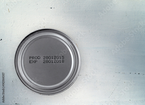 manufacturing date and expiry date printed on bottom of aluminum can (foods processed) on rustic white zinc kitchen counter, product information and instruction for consumer, top view with copy space