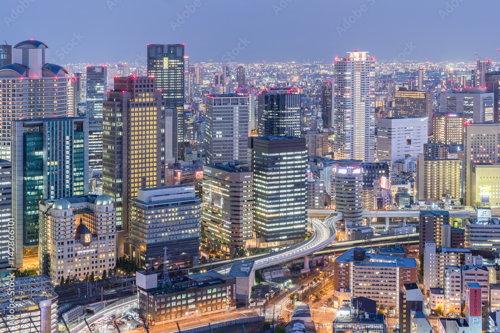 Fototapeta premium Widok na miasto Osaka z drogą ekspresową i wysokim budynkiem o zmierzchu