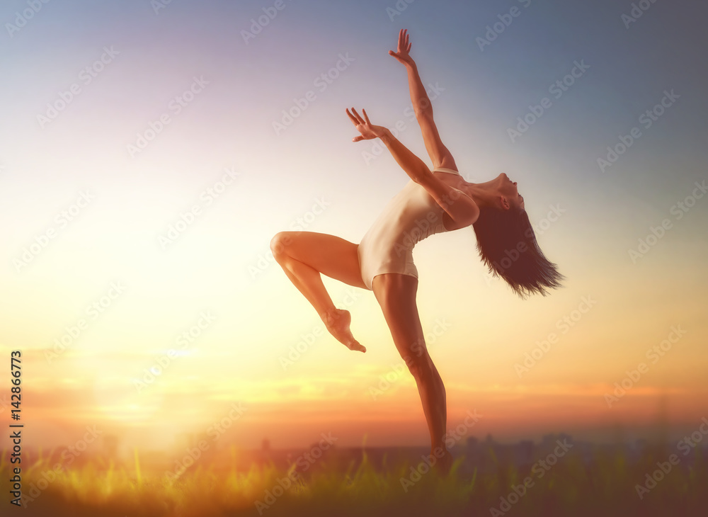 Fototapeta premium woman is dancing on sunset
