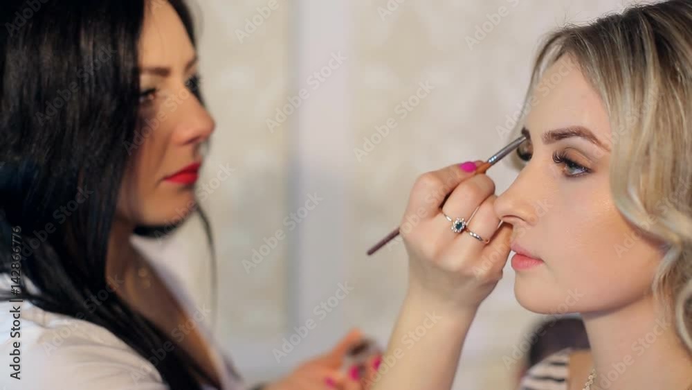 Make-up work. Makeup artist paints lips of a beautiful girl. Make-up work. Makeup artist paints lips of a beautiful girl.