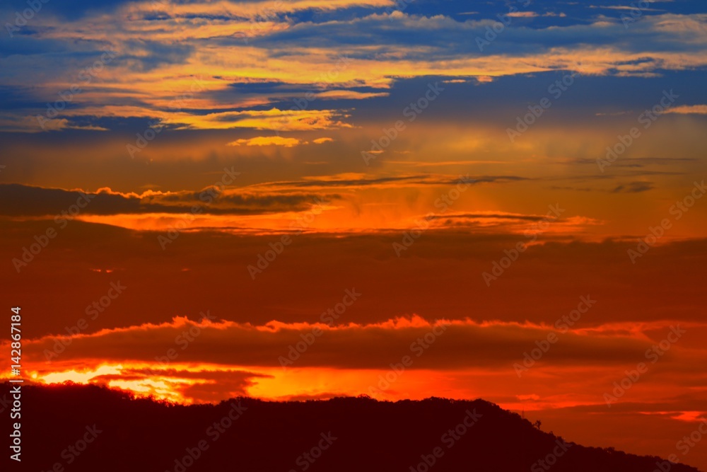 sunset in sky and cloud, beautiful colorful twilight time with mountain silhouette