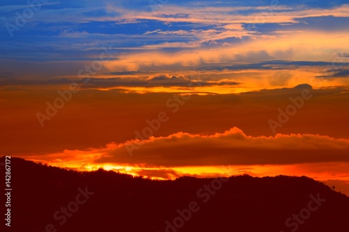 sunset in sky and cloud, beautiful colorful twilight time with mountain silhouette © pramot48