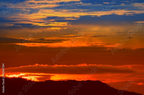 sunset in sky and cloud, beautiful colorful twilight time with mountain silhouette © pramot48